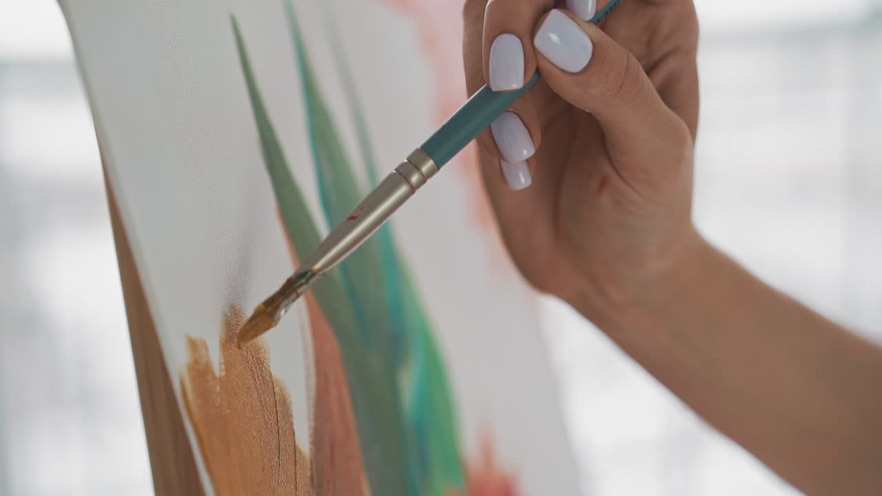Una donna disegna una lussureggiante pianta tropicale su una tela bianca in studio.
