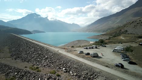 Parking-area-with-parked-cars-and-camopers-overlooking-lake-of-Mont-Cenis-in-France