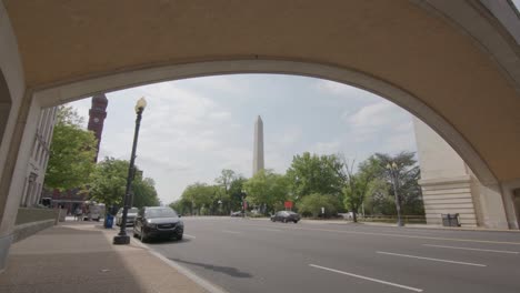 a slow-motion push into the washington monument under a bridge with moving taffic in washington, dc