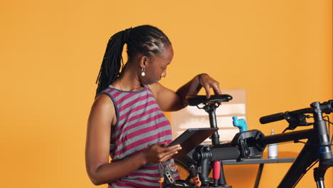 Woman-following-online-guide-on-tablet-screen-to-learn-how-to-fix-malfunctioning-bike