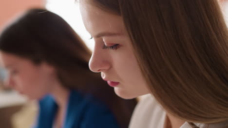 대학 수업에 앉아 강의를 듣는 학생, 대학 오디토리에 앉아 교육 자료를 듣는 여성 학습자