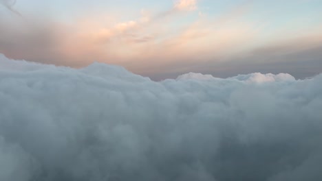 POV-flying-through-a-divine-pastel-color-sky-shot-from-an-airplane-cabin-at-sunrise