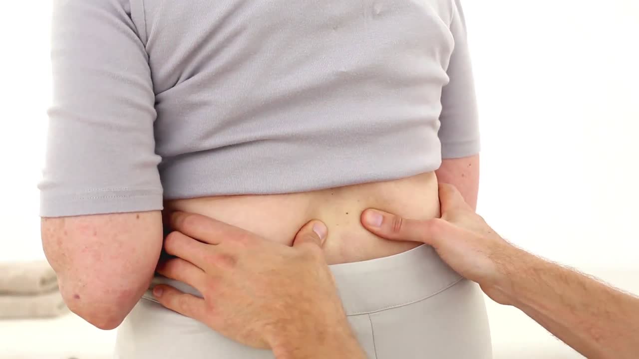 fisioterapeuta masajeando a pacientes de edad avanzada en la parte inferior de la espalda