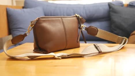 brown leather crossbody bag on a table