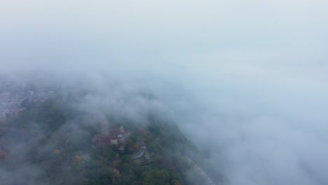 aerial ascent into the fog with a hint of the cloisters and the george washington bridge in upper manhattan new york city