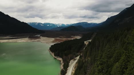 slow aerial drone shot of trees and lillooet lake in british columbia, canada