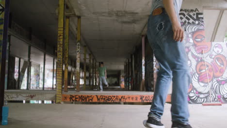 chicos caucásicos patinando en un edificio en ruinas.