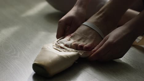 ballet dancer tying pointe shoes