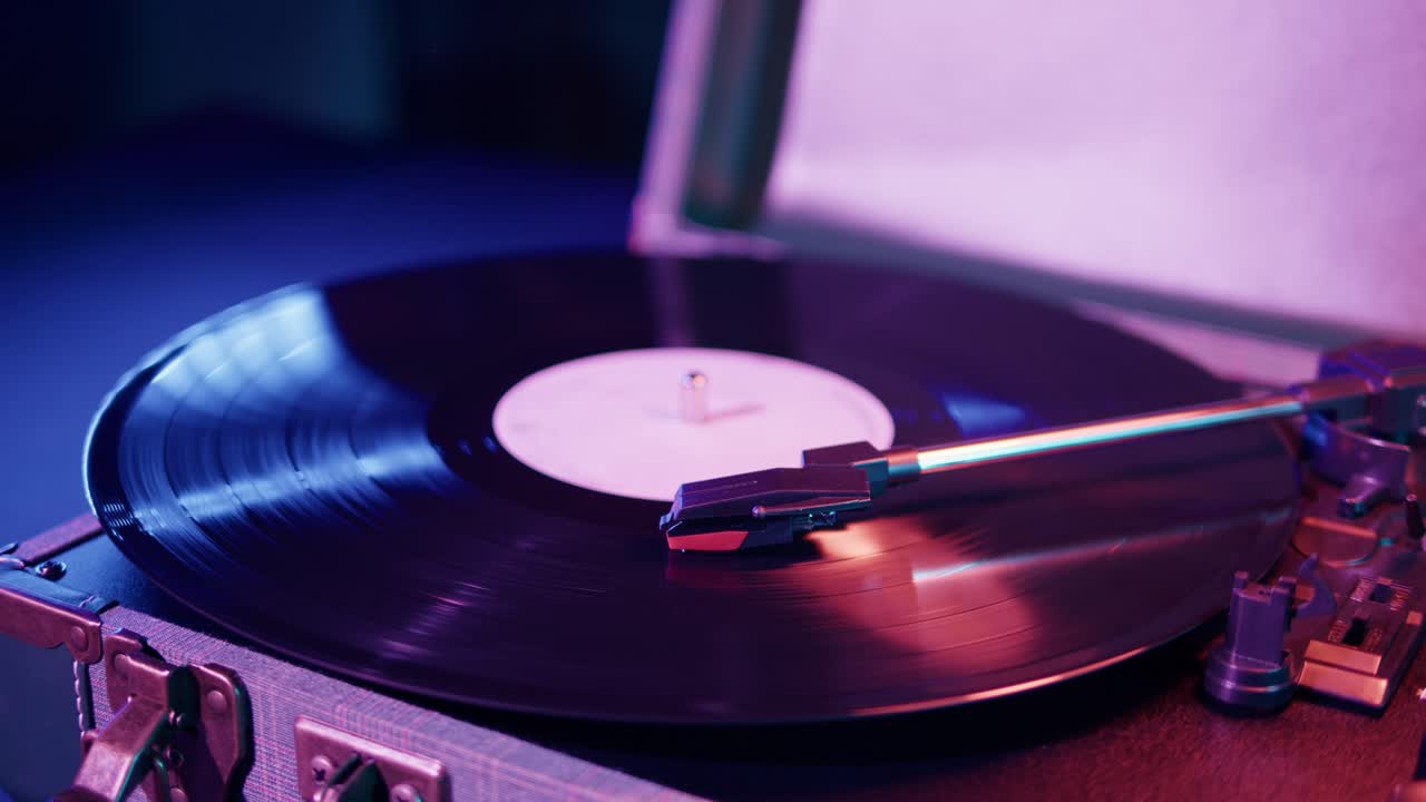 Disco in vinile retrò che gira su un giradischi con luci al neon colorate.