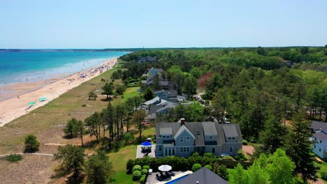 drone captures a maine beach house oasis. big windows, sunny deck, oceanfront yard, and patio create a perfect coastal property for real estate buyers seeking peace and seaside living.