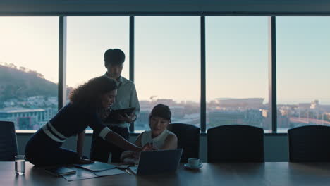 business-people-working-late-team-leader-woman-meeting-with-colleagues-discussing-project-manager-sharing-ideas-on-computer-group-of-executives-brainstorming-in-office-at-sunset