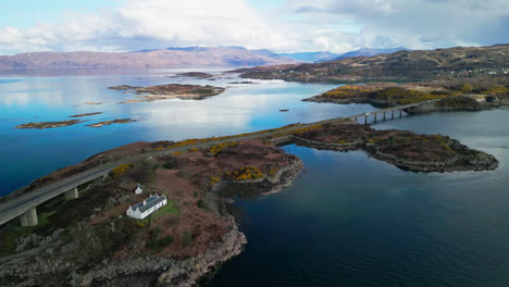 aerial pullback above cars driving along scenic skye bridge in scotland