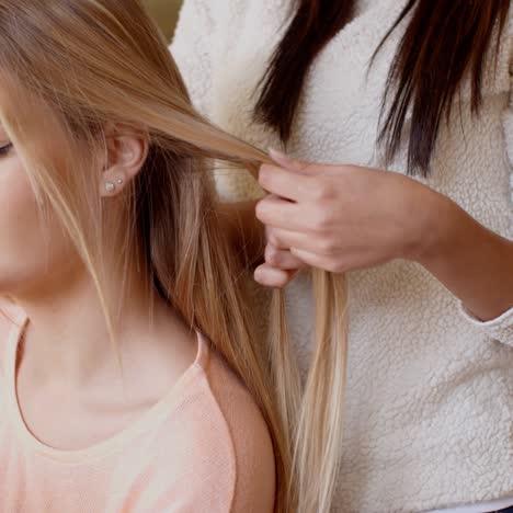 woman looking away while friend is fixing her hair