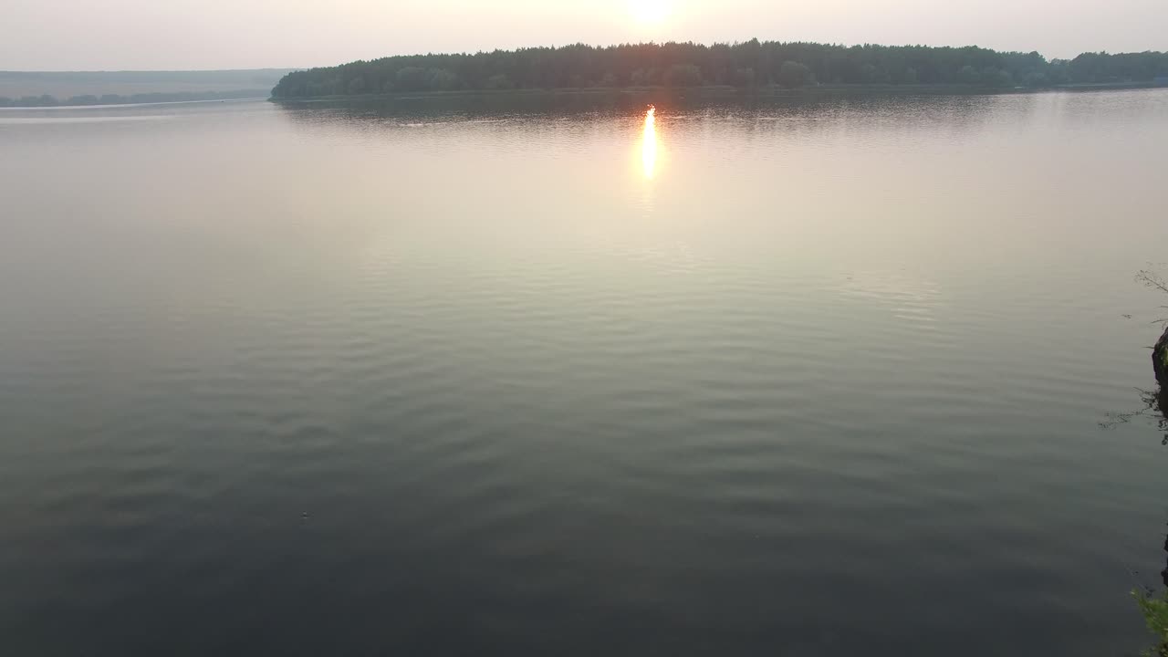Couple Resting On River Bank. Aerial shot of a smiling couple resting on river bank in nature