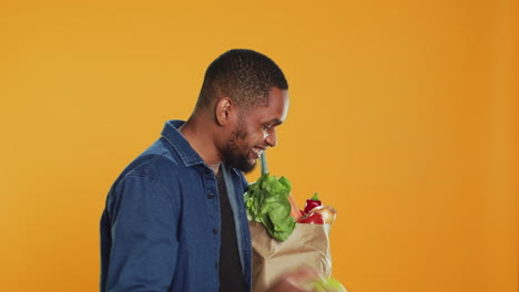 Male-person-playing-around-with-a-green-apple-in-studio