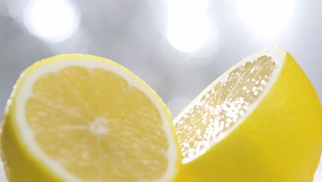 water spray particles falling on fresh half cut lemon, slow motion shot