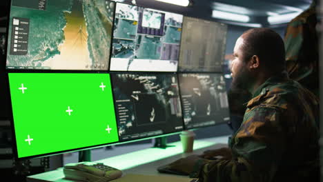 Military-agent-working-in-control-room,-using-software-on-tablet