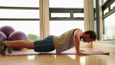 hombre guapo y en forma haciendo flexiones en el suelo.