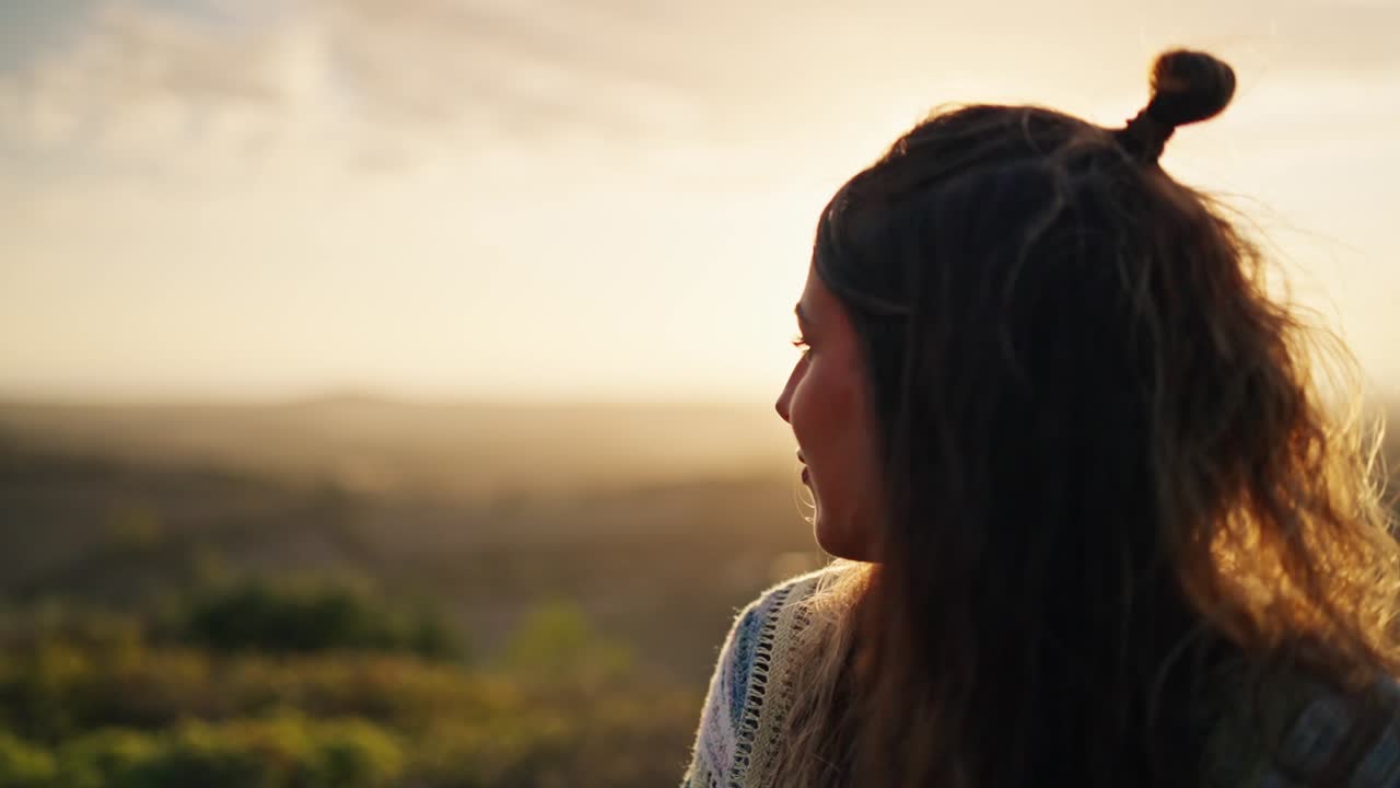 disparo en cámara lenta de un modelo posando y sonriendo con el atardecer vibrante detrás