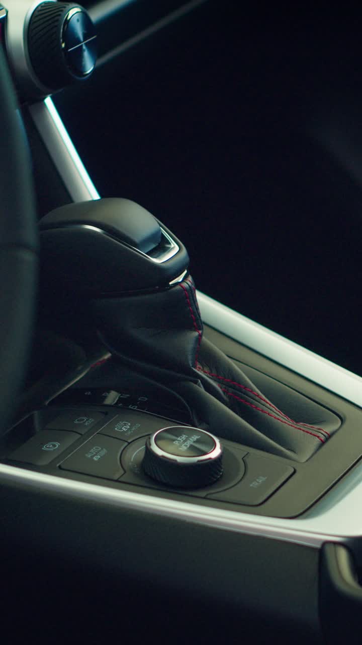 Primo piano del selettore del cambio e dei comandi negli interni di un'auto moderna