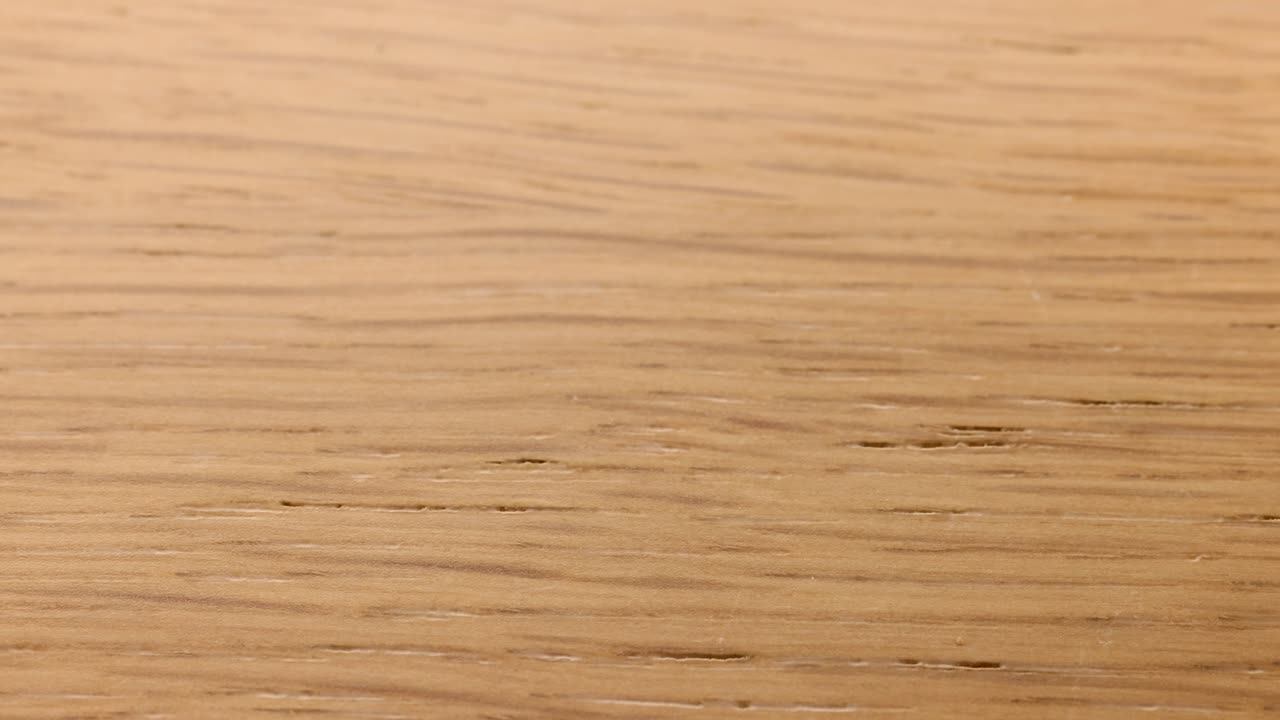 Various chakra stones fall onto a wooden surface, captured in natural lighting with a focus on movement and color