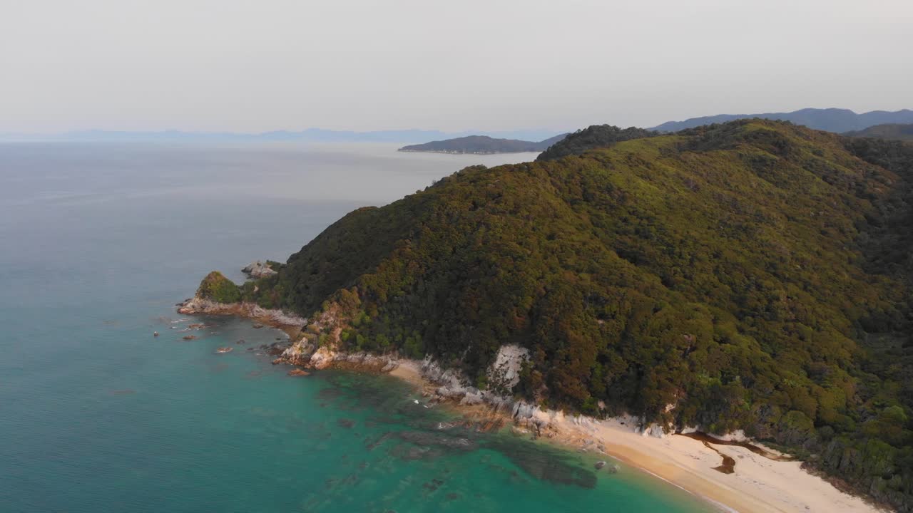 volando sobre la pintoresca costa de nueva zelanda en una cálida tarde de verano