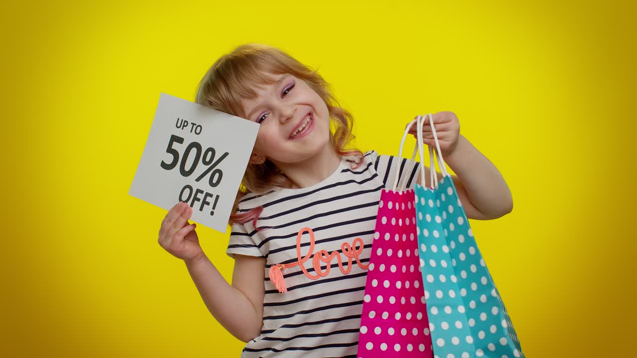 niña emocionada por una venta con bolsas de compras y 50% de descuento