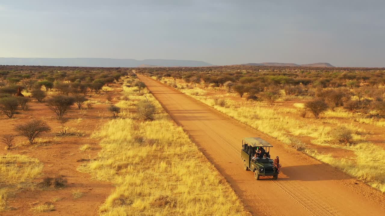 antena de un jeep safari que viaja por las llanuras de áfrica en la reserva de caza de erindi namibia con un guía nativo de observación de la tribu san sentado en el frente observando la vida silvestre 3