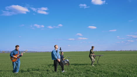 young musical band giving a concert on field. friends perform music with musical instruments under blue sky. outdoor entertainment