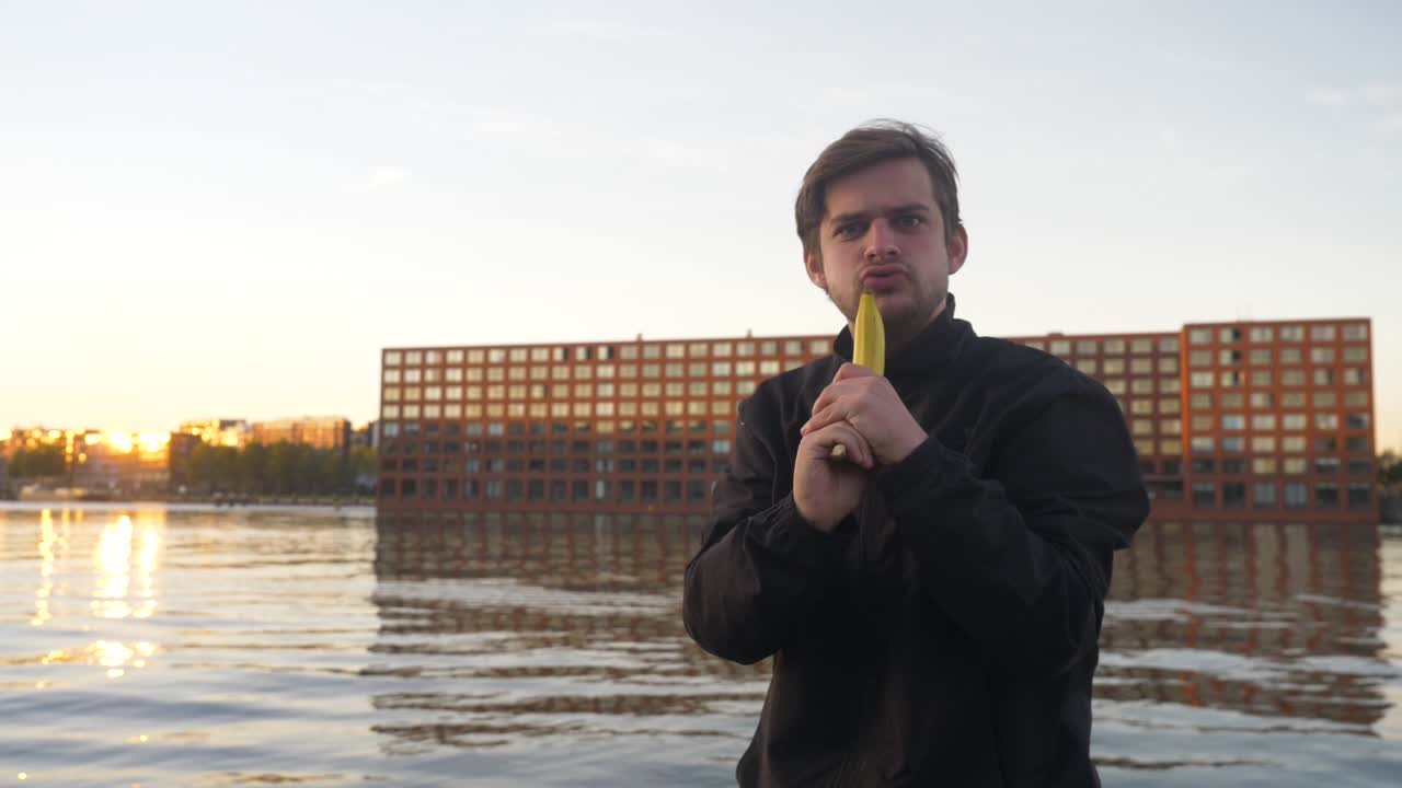 video de un hombre que finge dispararle a un plátano como si fuera una pistola en un muelle.