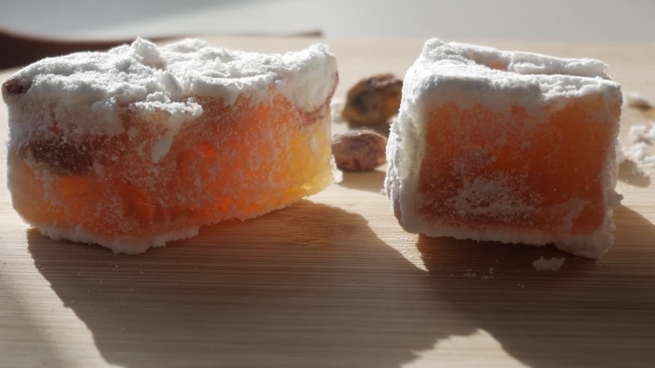Soft orange loukumi cubes with sugar dust in sunlight, traditional Cyprus delight
