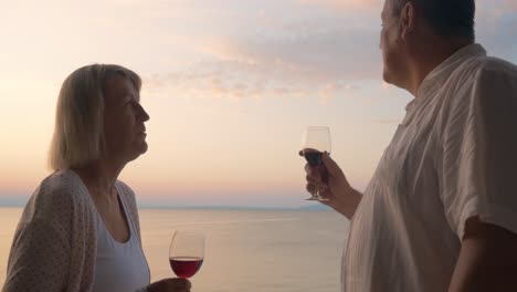 mature sweethearts enjoying sea view and wine