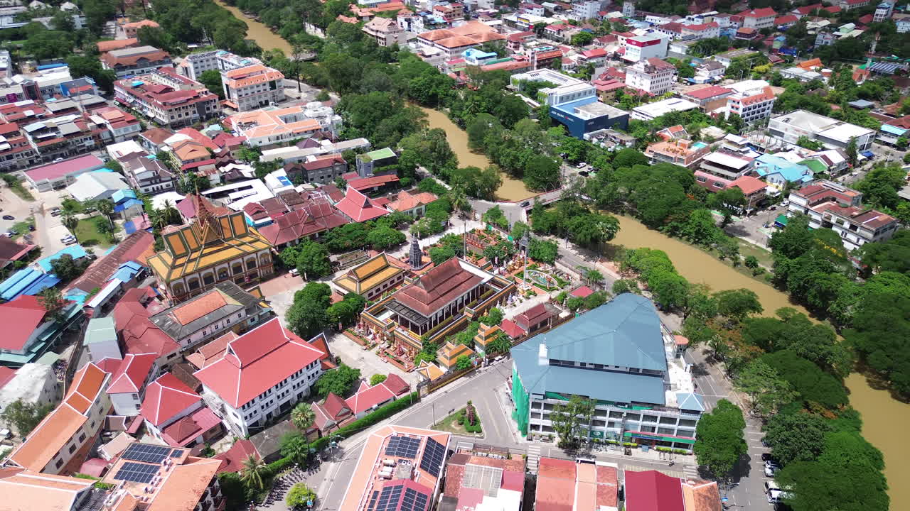 Aerial establishing of Siem Reap cityscape with traditional rooftops and colorful streets, orbit