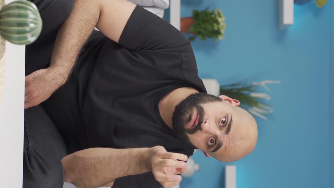 카메라를 사려 깊게 바라보는 남자의 수직 비디오.