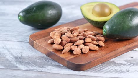 close up of slice of avocado and almond nut on chopping board,