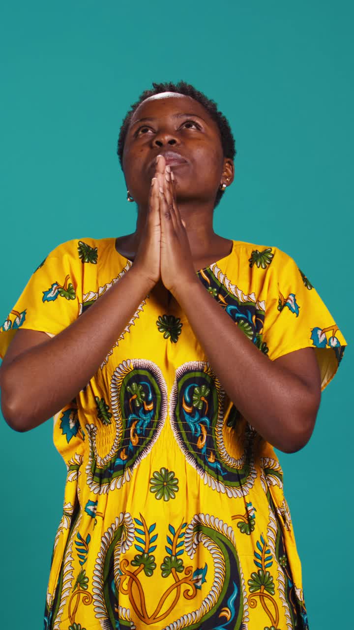 African Woman Praying with Eyes Closed in Traditional Dress