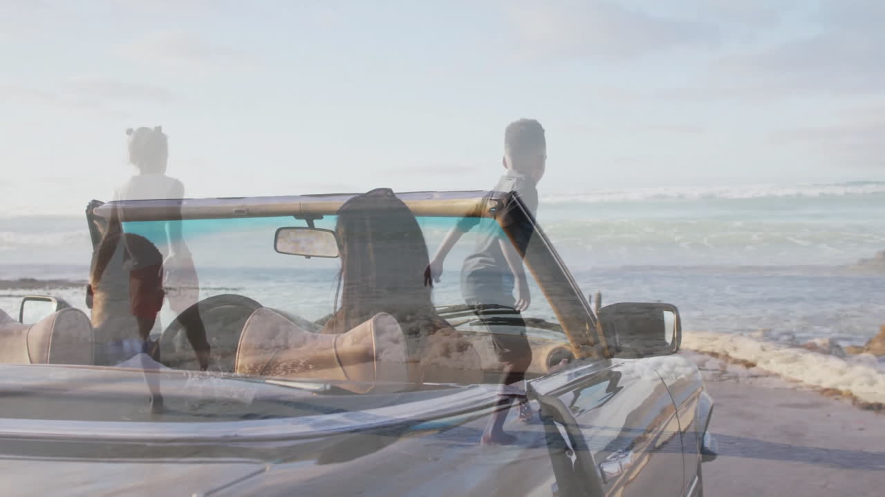 Convertible car by beach with children playing and enjoying animation nearby