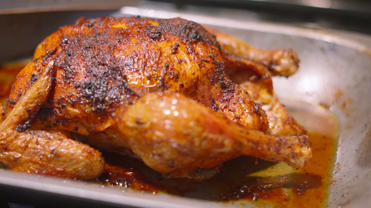 Whole Roasted Chicken in Baking Pan with Delicious Crispy Skin with Legs and Wings Ready to Carve and Eat. Traditional British Roast Sunday Lunch Dinner Food.