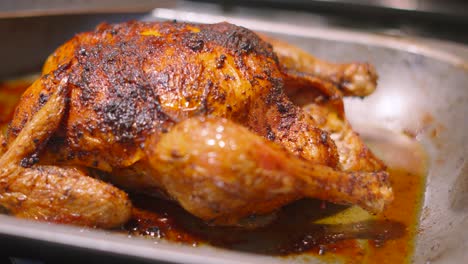 whole roasted chicken in baking pan with delicious crispy skin with legs and wings ready to carve and eat. traditional british roast sunday lunch dinner food.
