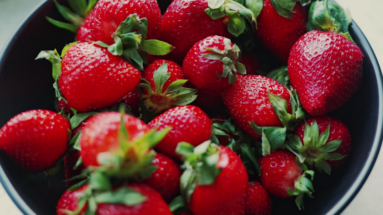 Close-up of red strawberries in bowl highlights vibrant texture and freshness