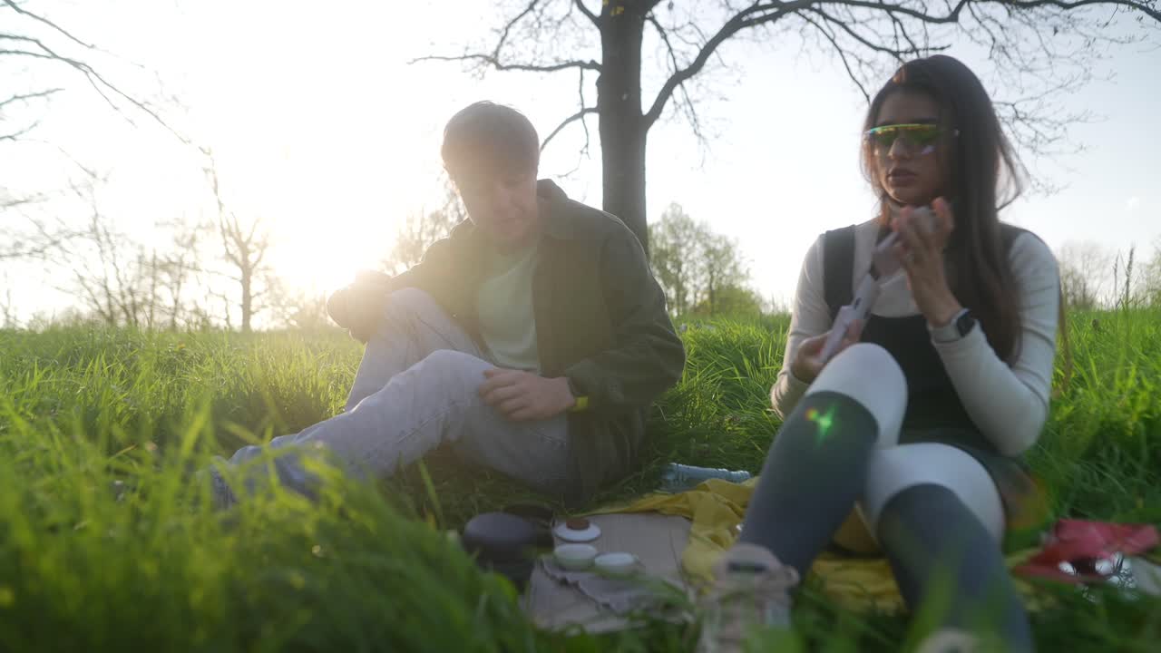 Couple enjoying a picnic in a park at sunset