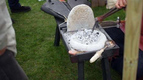 Portable-forge-with-hot-coals-and-tools,-used-for-live-demonstrations-in-metalworking-and-historical-reenactments