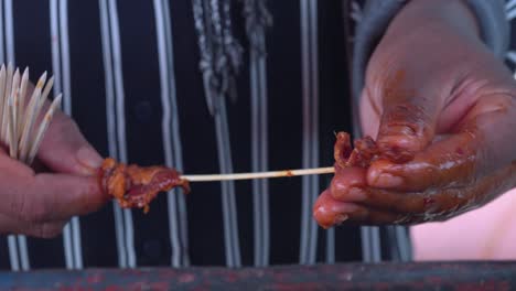 adding meat to a skewer prior to grilling fro street food