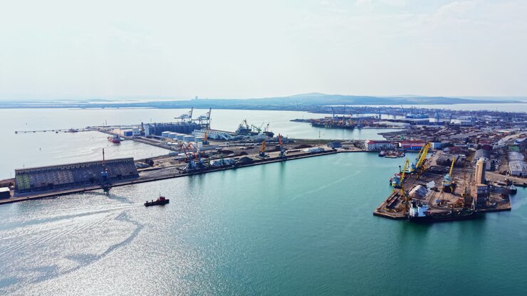 View of the busy port with ships and cranes in the harbor during daytime in an industrial area, showcasing the maritime activity and infrastructure