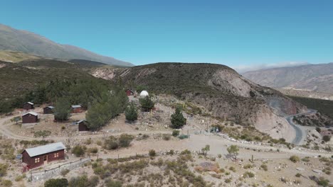 Aerial-above-the-Amaicha-del-Valle-valley-in-argentina-with-scenic-mountain-view-and-astronomical-observatory-buildings