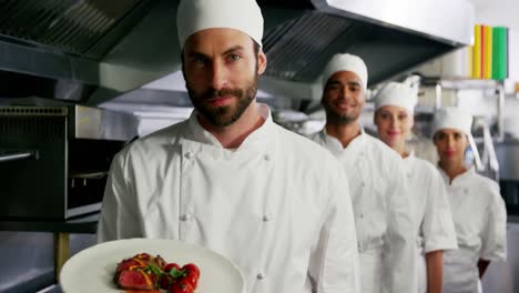 Team-of-chefs-with-one-presenting-a-dish