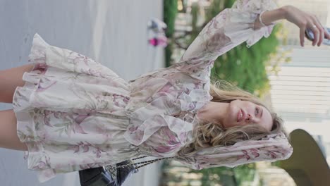 woman taking a selfie in a floral dress in a city