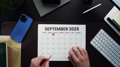 person marking dates on september 2025 calendar