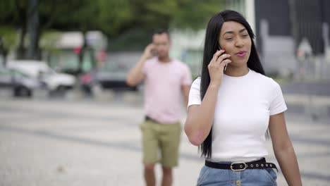 Front-view-of-smiling-young-woman-talking-on-smartphone