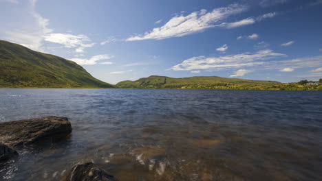 Zeitraffer-Eines-Panoramas-Mit-Blick-Auf-Das-Felsige-Seeufer-An-Einem-Sonnigen-Tag-In-Irland